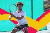 Man in tennis gear concentrates on returning an inbound shot on a tennis court for a story about the benefits of playing tennis.