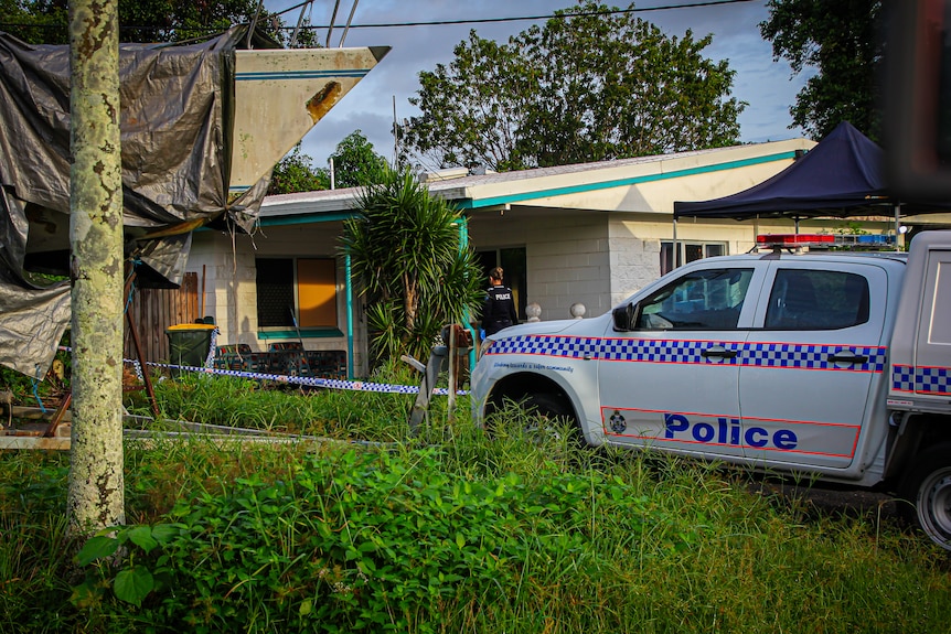 Police investigators photograph a crime scene at a single-storey home.