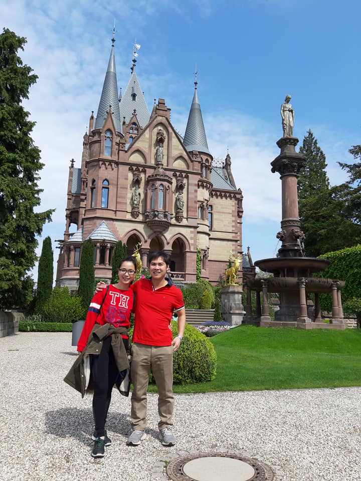 Dos personas posan para una foto frente a un castillo en Alemania