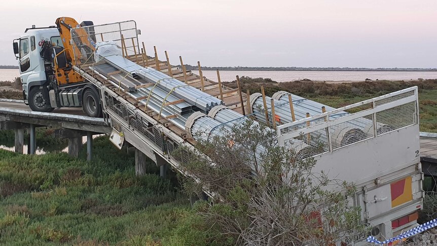 A truck and its trailer hanging off a bridge near Adelaide's salt plains