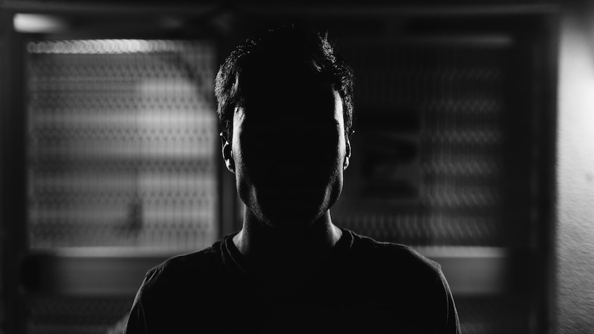 a man silhouetted while sitting