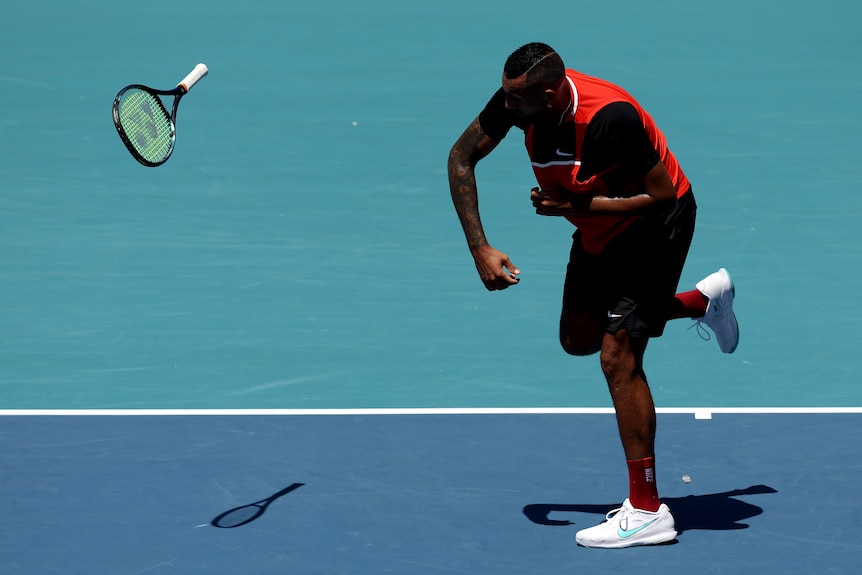 A man hurls a tennis racket across the court