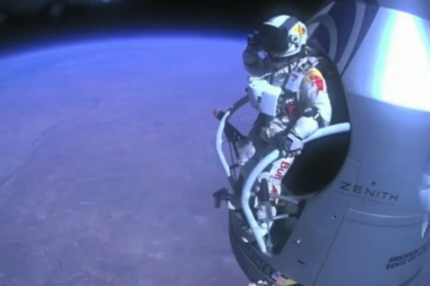 Daredevil Felix Baumgartner salutes before jumping out of his capsule.