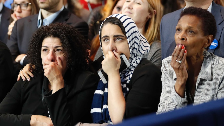 Supporters of U.S. Democratic presidential nominee Hillary Clinton hold their hands to their mouths as they watch the results.