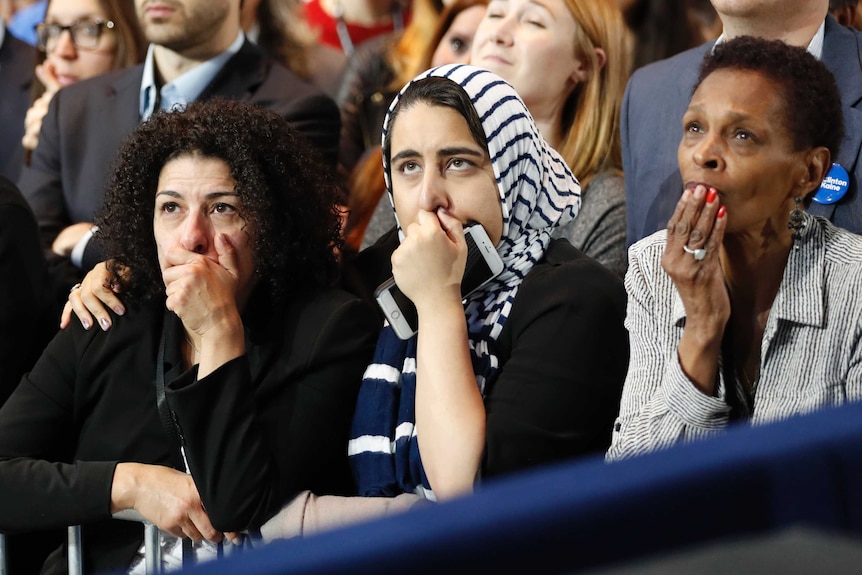 Supporters of U.S. Democratic presidential nominee Hillary Clinton hold their hands to their mouths as they watch the results.