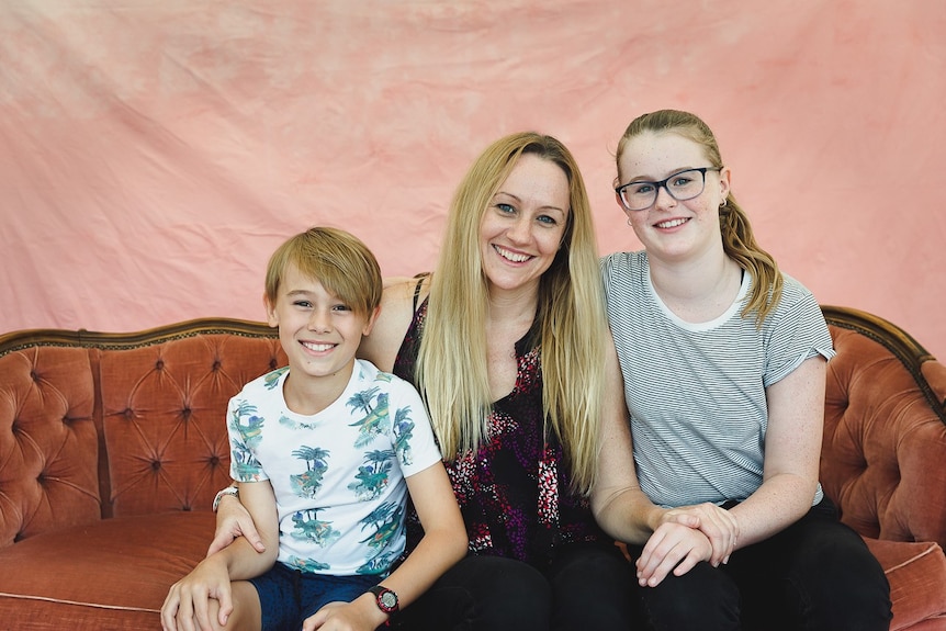 Dr Julie Wixey sitting between her two children. A younger boy on the left and older girl on the right.