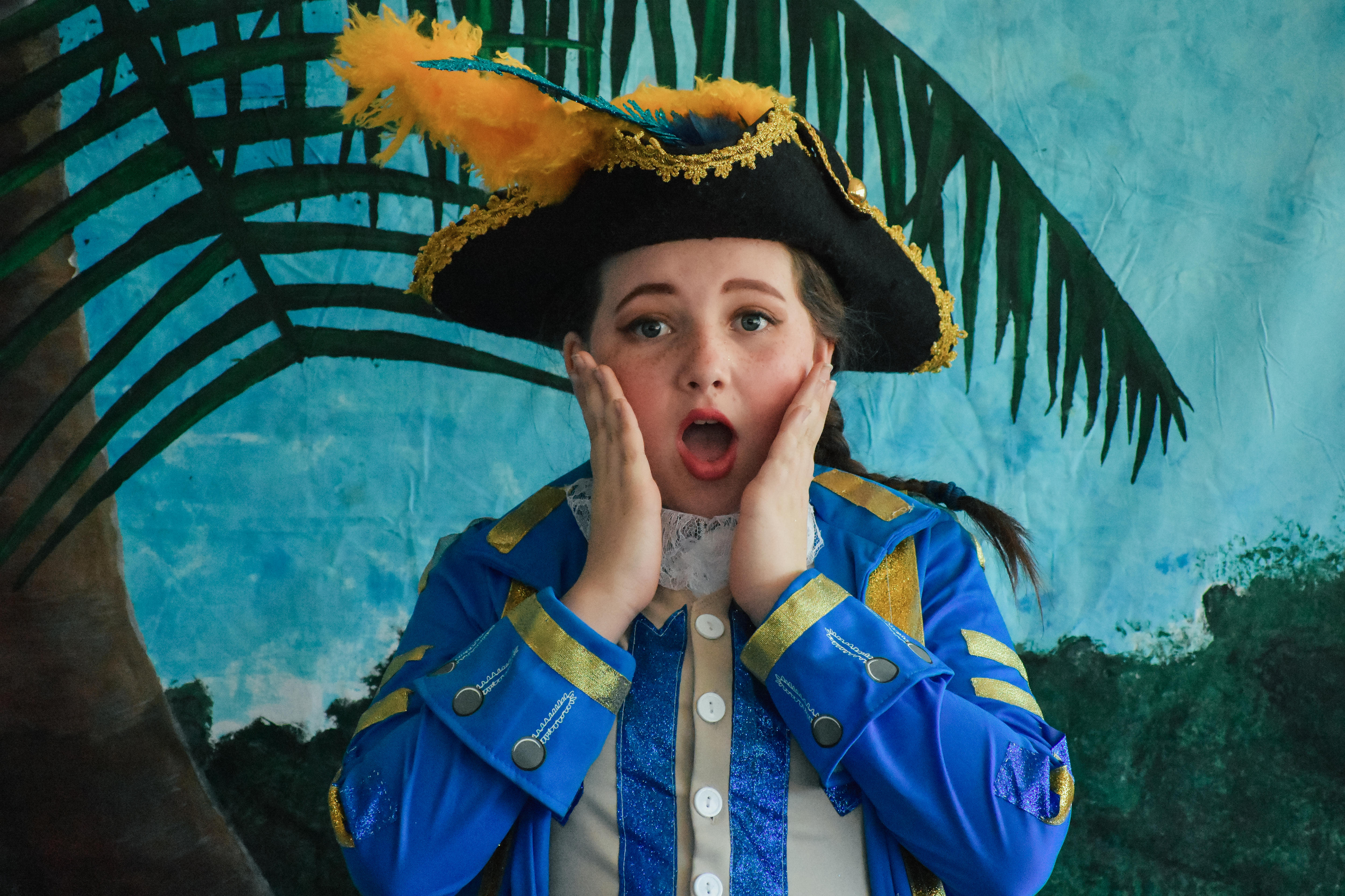 a young performer in a sailor's outfit looks at the camera