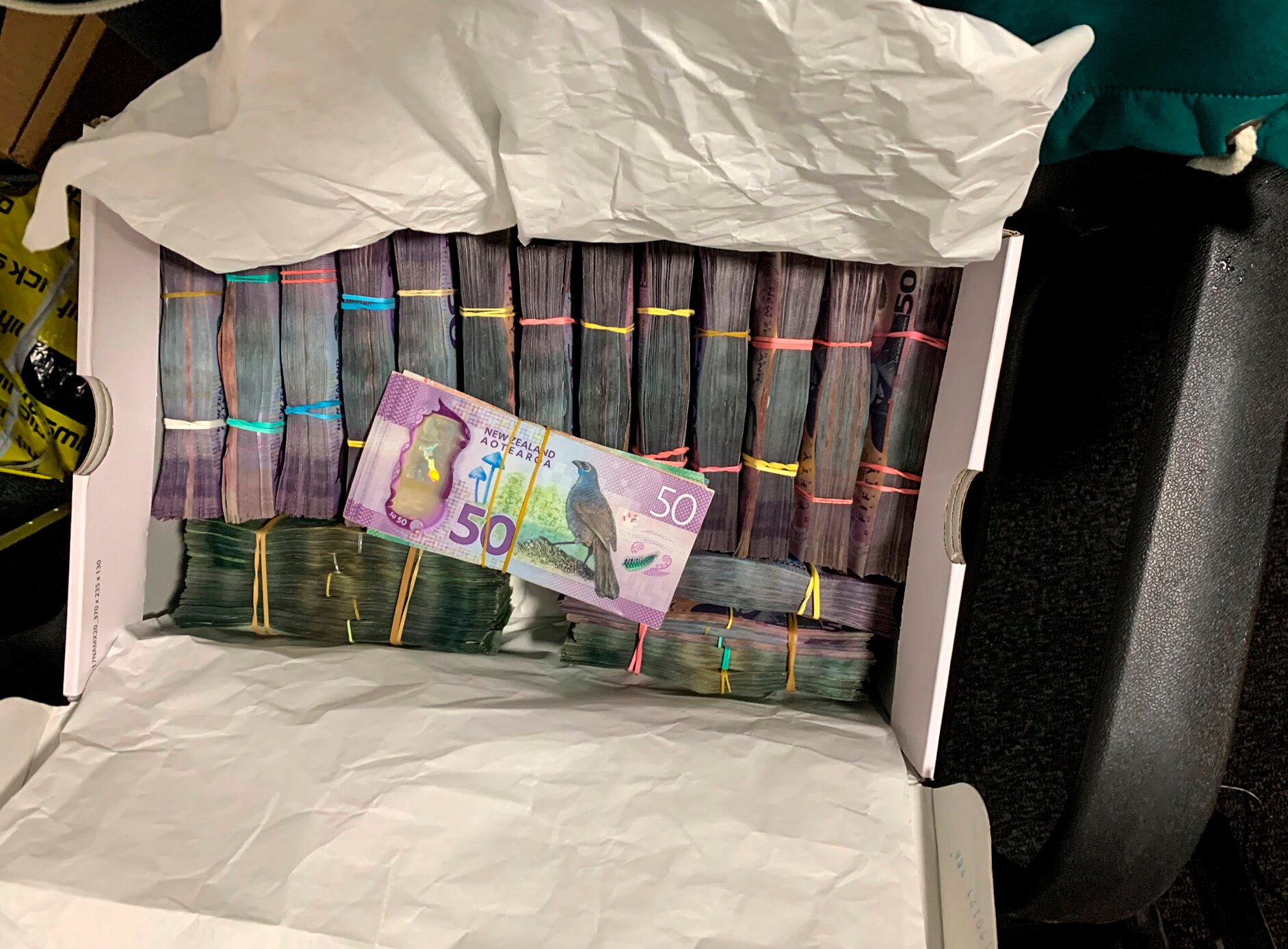 A box containing bundles of New Zealand currency.