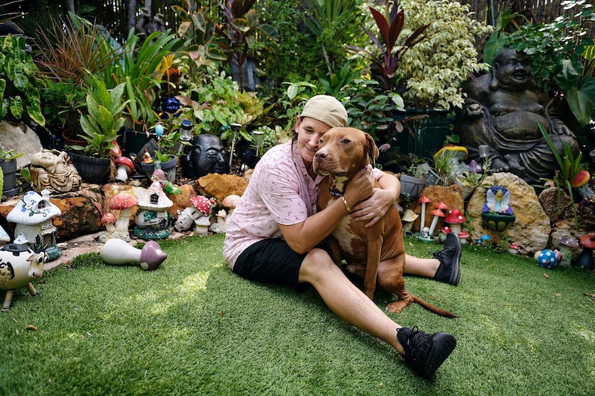 Renae "Rocket" Bretherton with her dog Ollie in a garden.