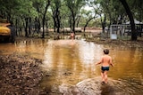 Two children play in water in the bush after a deluge at Stawellton Station, north-east of Richmond.