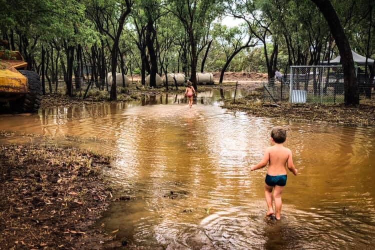 Two children play in water in the bush after a deluge at Stawellton Station, north-east of Richmond.