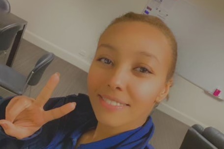 Lidya Teferi takes a selfie wearing an Ambulance Victoria uniform. Her hand is in a peace sign. 