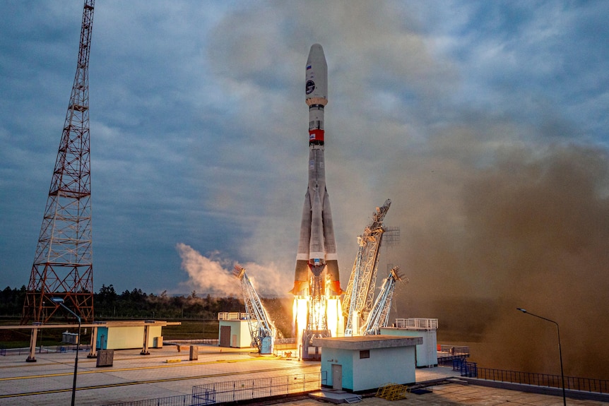 Flames emerge from the bottom of a rocket as it lifts off