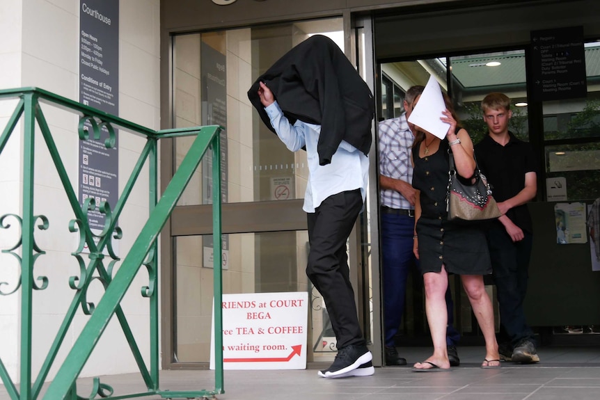 Nathan Sanger walks out of the Bega Local Court with a jacket covering his head. His family escorting him.