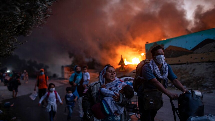 Migrants flee from the Moria refugee camp during a second fire in Lesbos, Greece