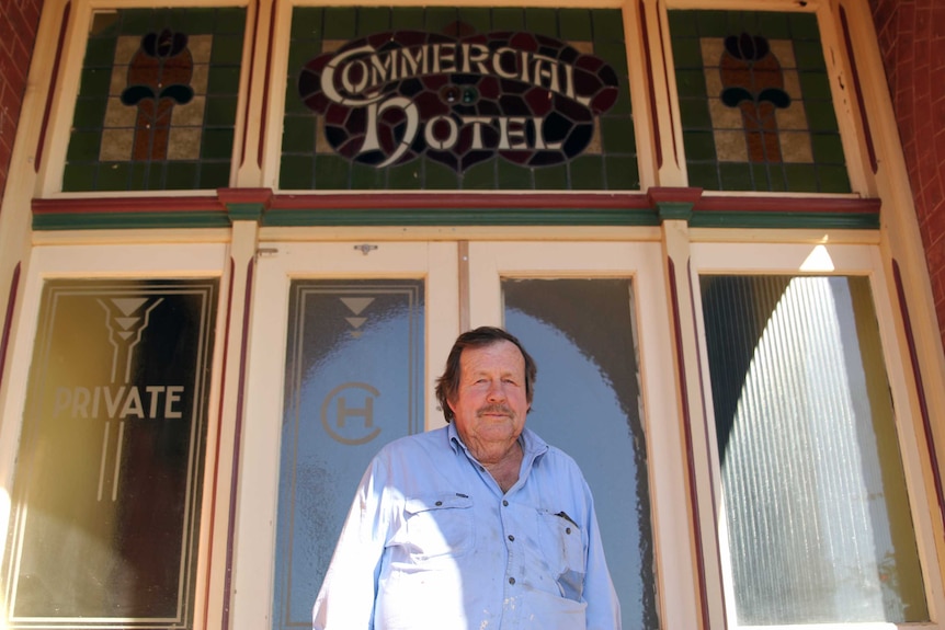 Older man Terry Brennan standing in front of the Mingenew Hotel front door.