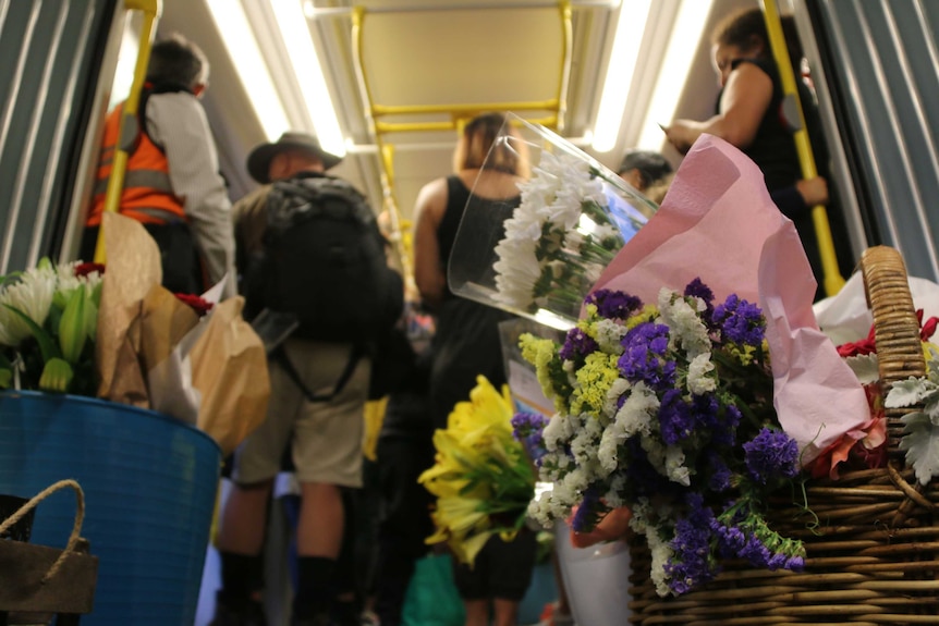 A basket containing flowers on a tram.