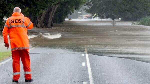 An SES worker monitors floodwaters on the Mossman-Daintree Rd.
