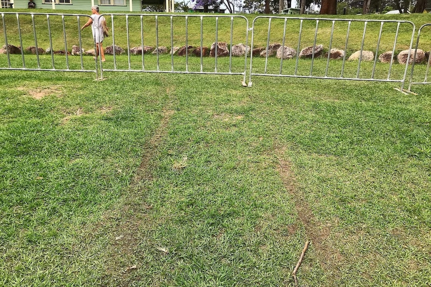 Temporary fencing on grass at a showground with tyre tracks visible