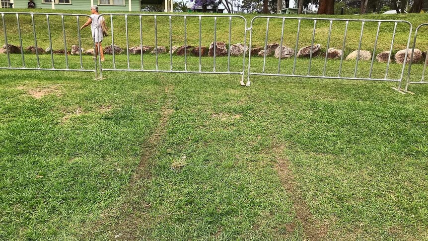 Temporary fencing on grass at a showground with tyre tracks visible