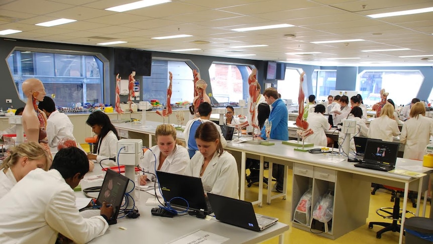 Students in lab coats in a classroom at the University of Tasmania.