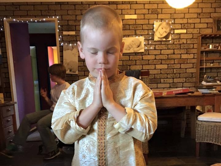 Oshin Kisko stands with his hands together in a prayer-like gesture.