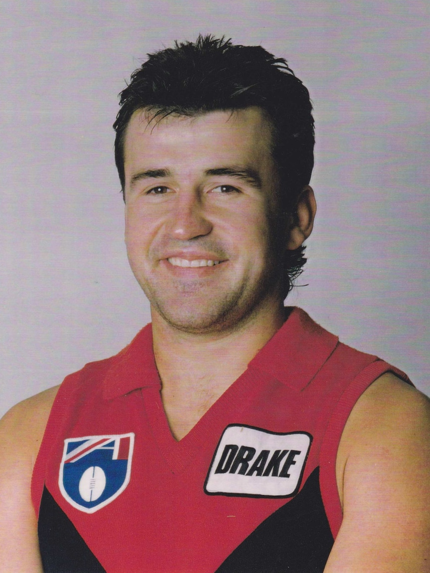 A portrait of a man in a Melbourne Football uniform.