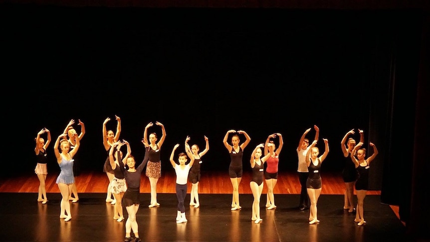 16 ballet dancers on stage auditioning for roles in Cinderella