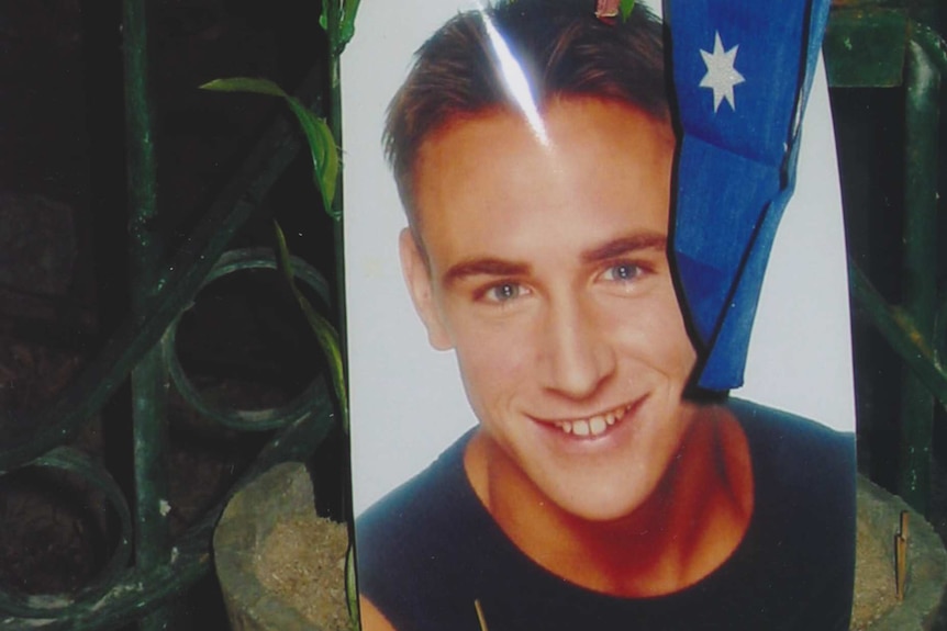 A photo of Billy Hardy sits in a potplant with the Australian flag after the Bali bombings that rocked the Sari nightclub.
