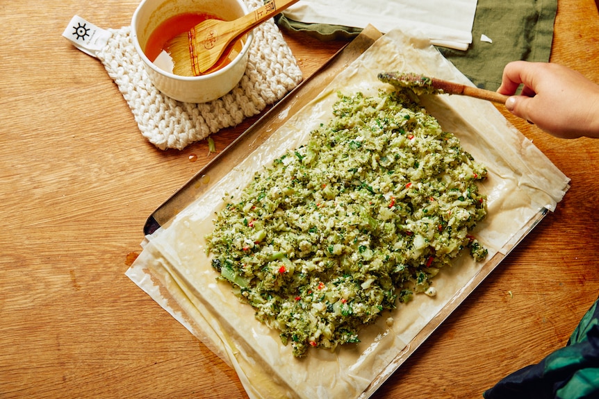 Filo pastry is brushed with butter and topped with a cooked broccoli and cheese mixture to make a vegetarian freeform pie.