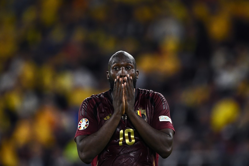 Romelu Lukaku holds his hands to his mouth in disappointment