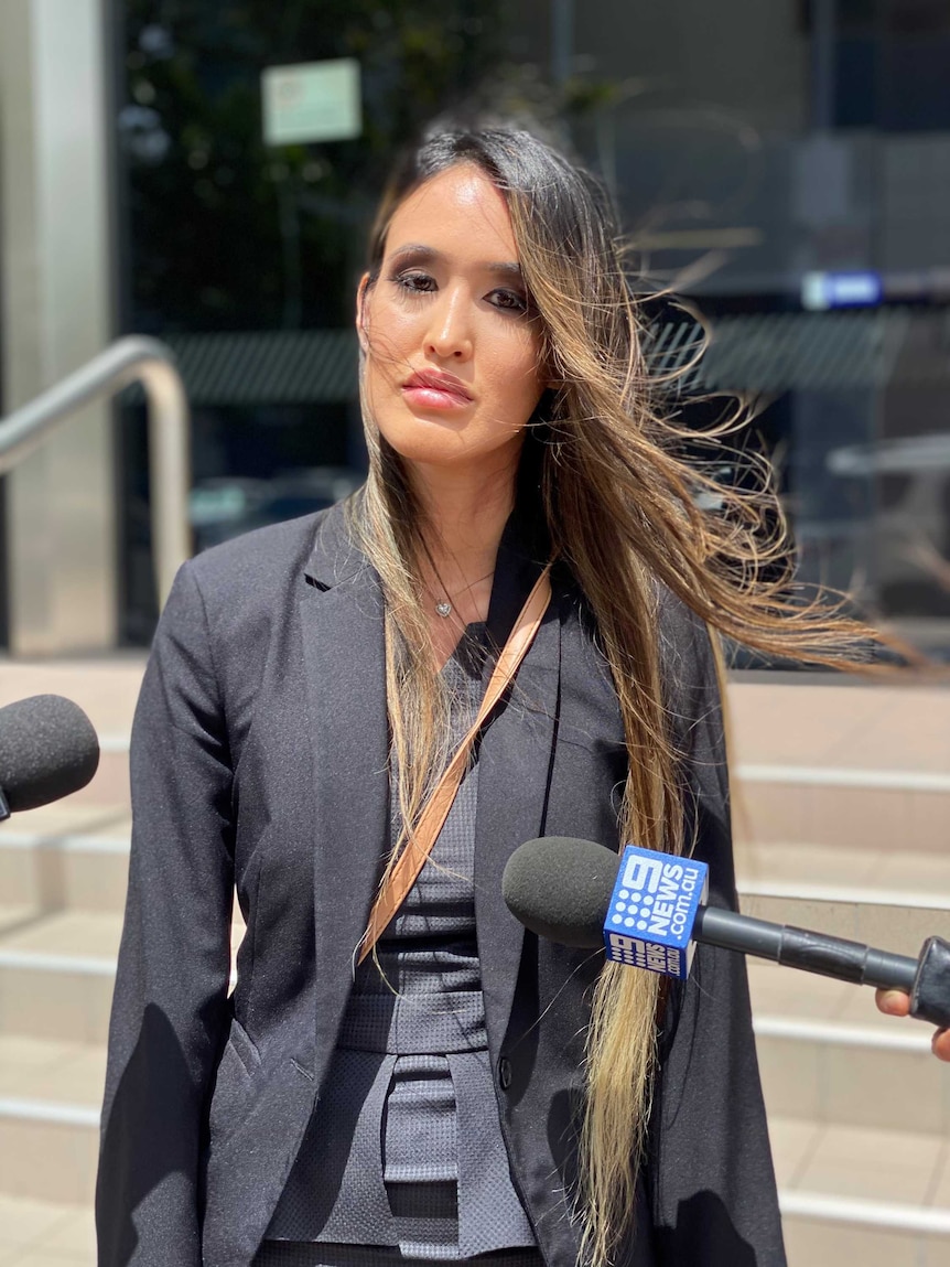 A woman in a suit standing outside court