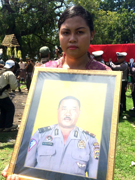 A woman holds up a photograph.