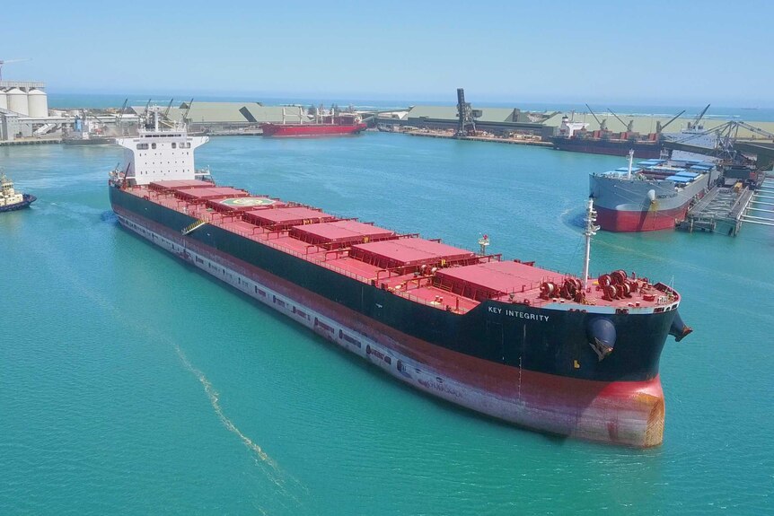 An aerial view of an iron ore carrier sailing out of Geraldton Port.
