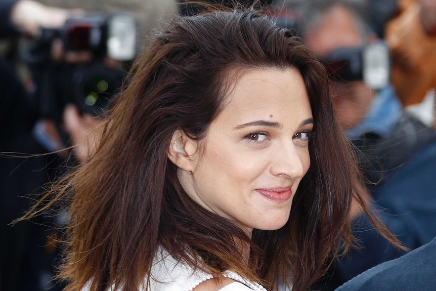 Asia Argento looks over her shoulder as she poses on the red carpet at Cannes in 2012