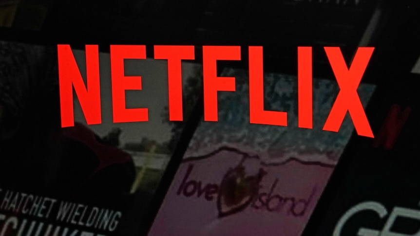 The word Net flix in the company's font in red colour overlayed on top of a dark screenshot of the website.