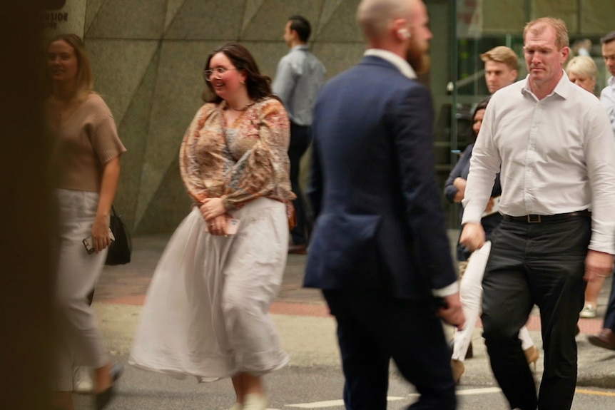 People walking along in business clothes. 