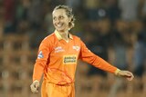 Ash Gardner, wearing orange, smiles after taking a wicket for Gujarat Giants in their WPL match against Delhi Capitals.