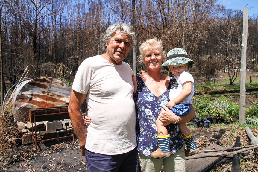 Noel and Trish stand amidst the carnage of their burnt out property.