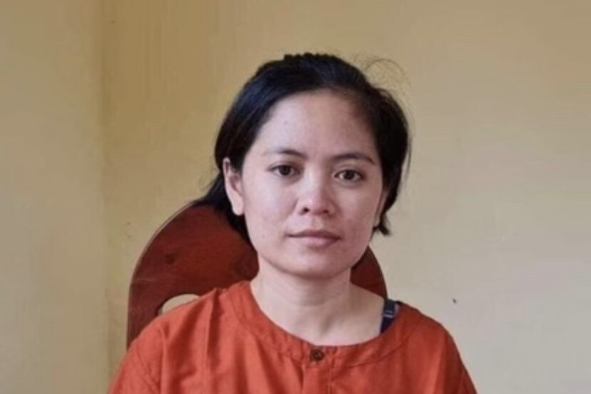 Cambodian woman with short hair in orange prison garb