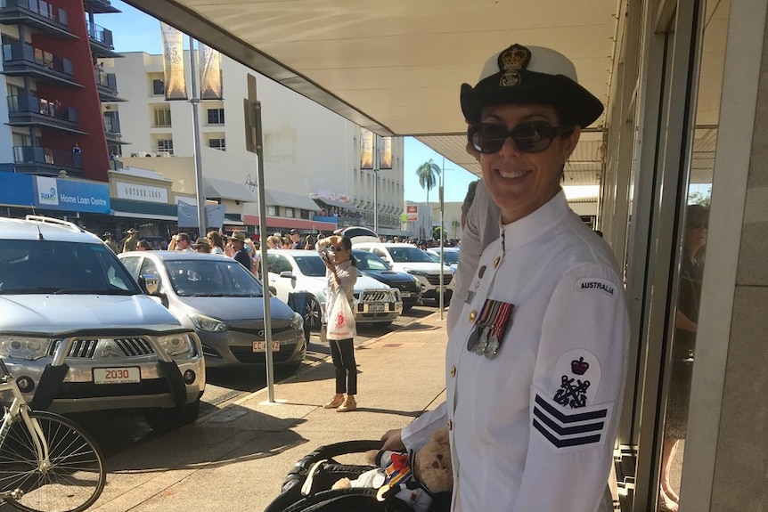 Navy Petty Officer Anita Rayner pushing a pram with a toddler inside