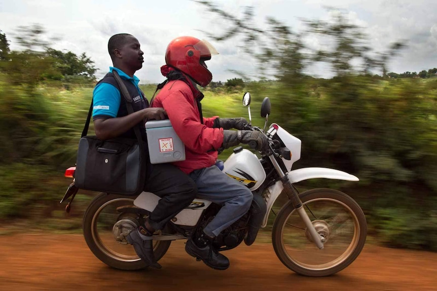 A health worker delivering a cooler box of Pneumococcal vaccine in Kenya