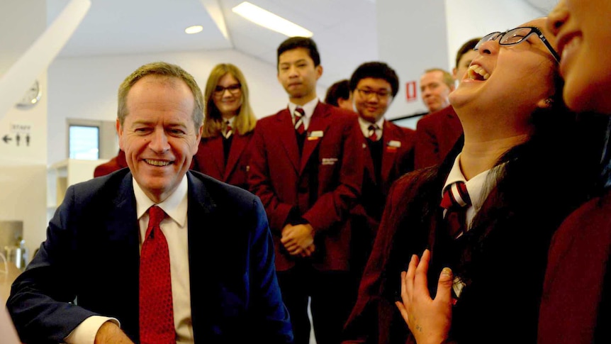 Opposition Leader Bill Shorten looks at a wind turbine as he meets students at Braybrook College