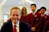 Opposition Leader Bill Shorten looks at a wind turbine as he meets students at Braybrook College
