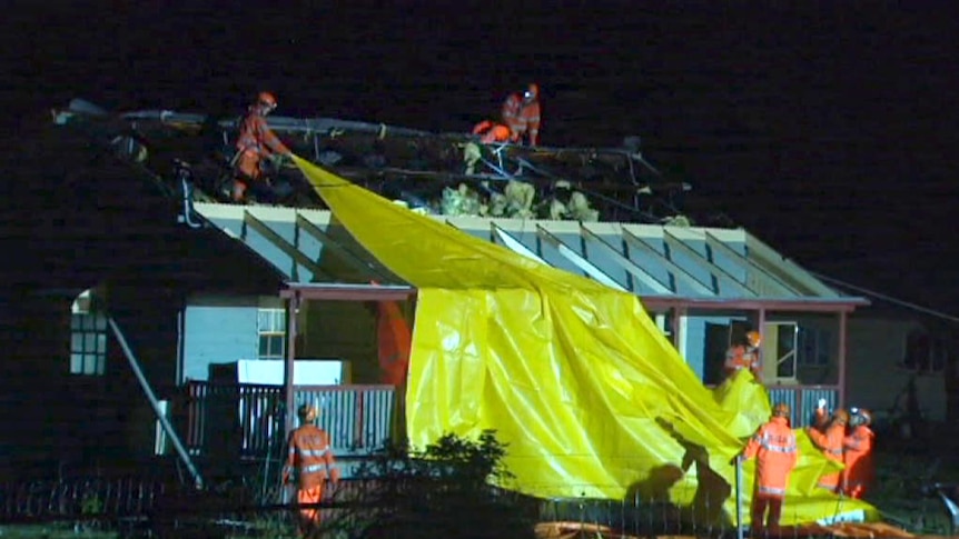 Emergency workers pull tarp on house with no roof at Pratten, near Warwick