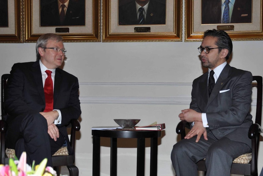 Ken Rudd looks towards a speaking Marty Natalegawa as the two men sit below portraits of men in suits