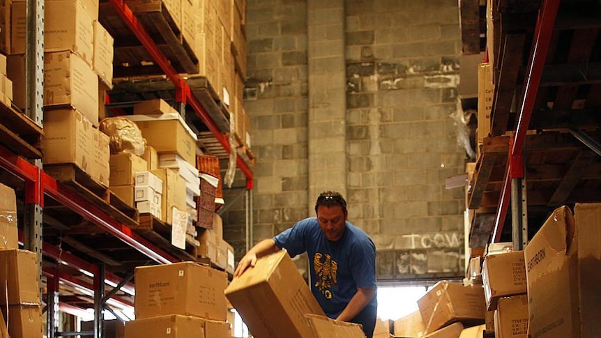 A man sorts through damaged merchandise in a flood-hit warehouse in Brisbane.