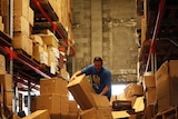 A man sorts through damaged merchandise in a flood-hit warehouse in Brisbane.