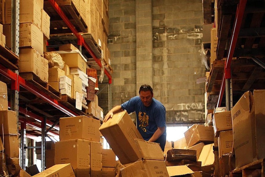 A man sorts through damaged merchandise in a flood-hit warehouse in Brisbane.