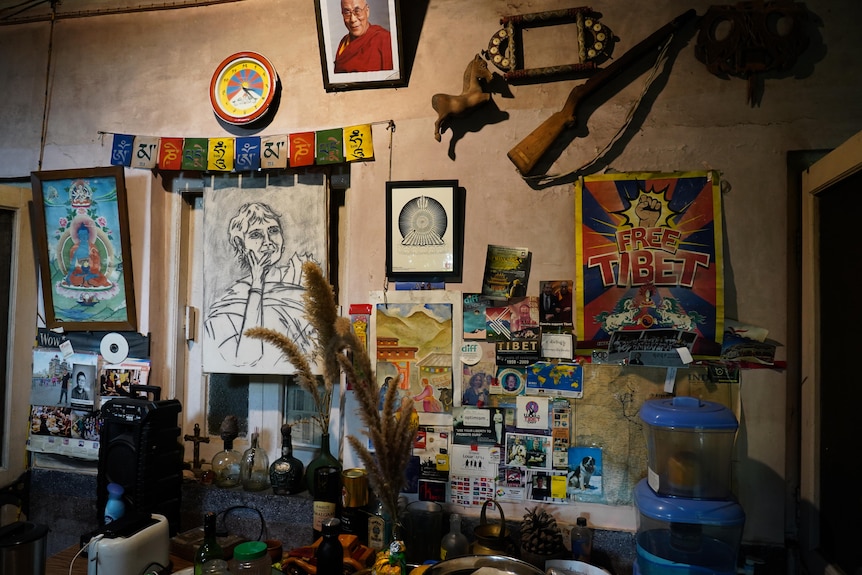 Posters, drawings and Tibetan peace flags adorn a wall.